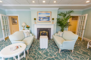 The newly renovated living room at Allerton House is complete with fireplace and baby grand piano