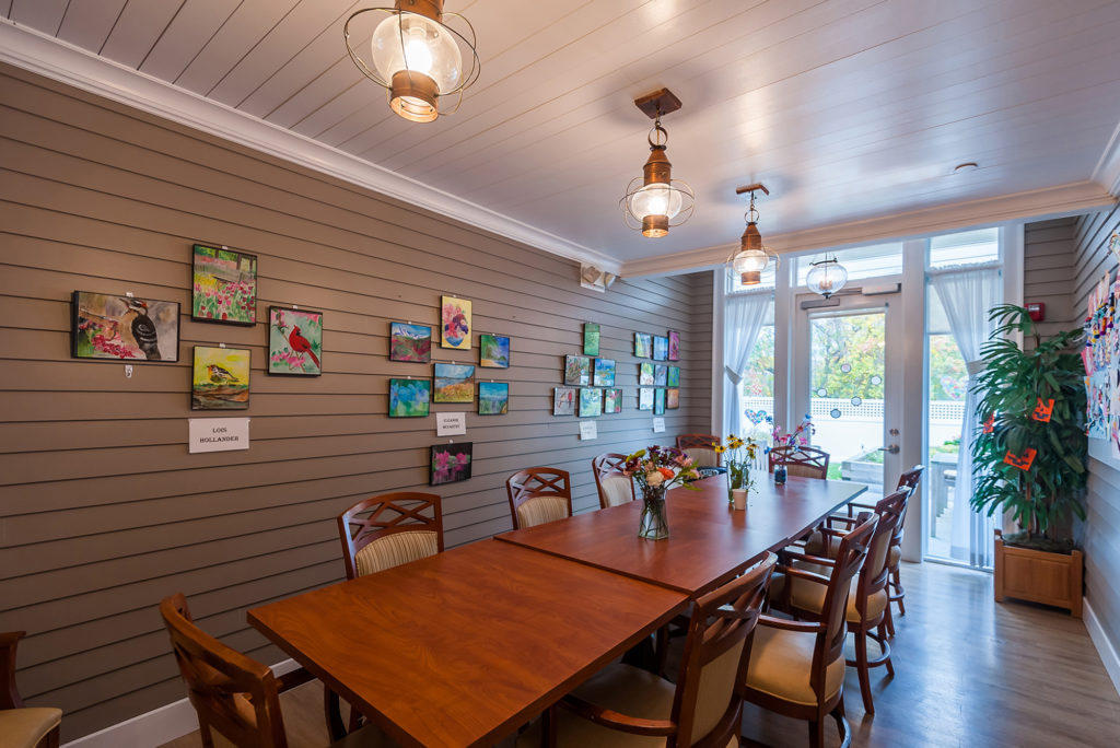 private dining room with resident art on the wall behind the long table