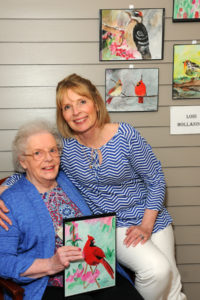 With a fondness for cardinals, resident Lois Hollander shares a special moment with her daughter Karen Thomson, as they both enjoy the art show at the Allerton House Memory Care Neighborhood in Hingham.