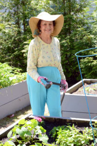Allerton House resident Martha Corey prepares to water one of the many garden beds at the assisted living community in Hingham.