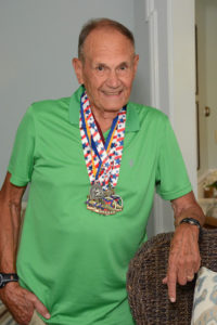 Hingham resident and marathoner Herman Messmer proudly displays some of his race medals.