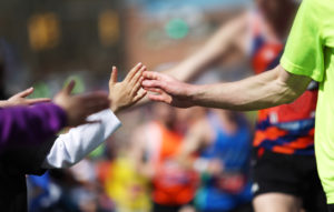 Kids give a high five to Boston Marathon runners.
