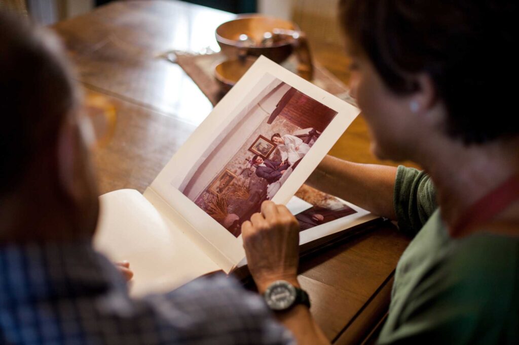 First point of view of a senior man and woman looking at a old wedding photo album