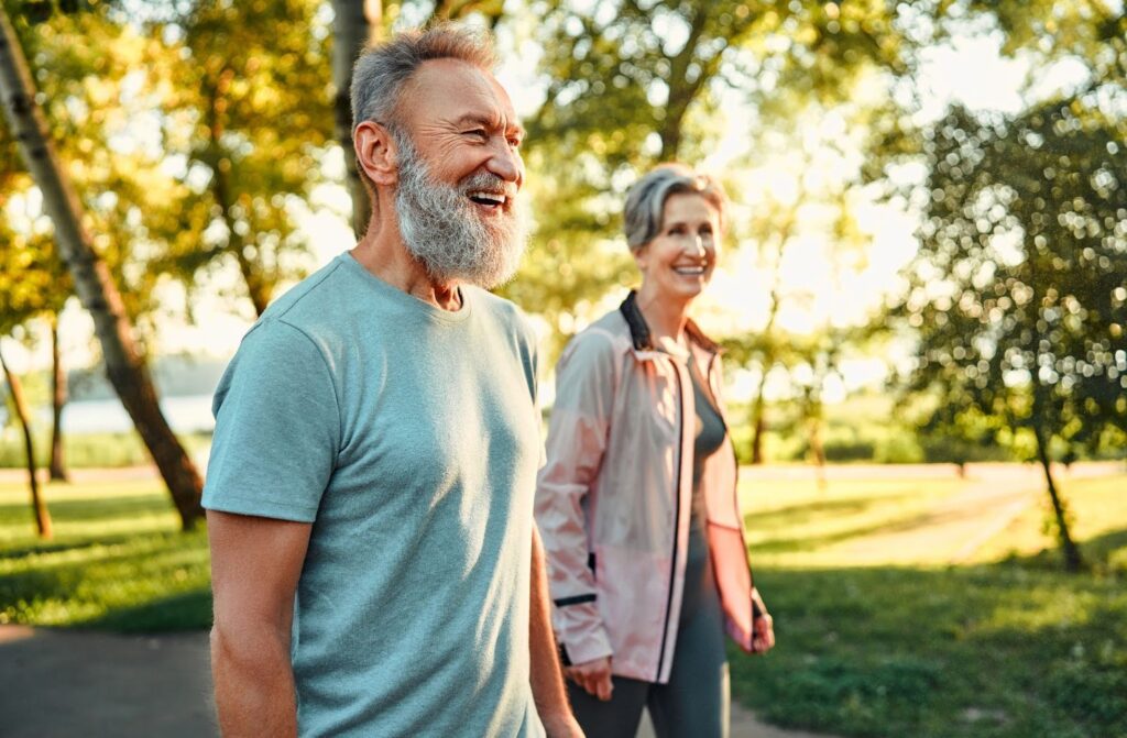Older couple walking outdoors enjoying wellness activities at Allerton House Hingham in Hingham, MA