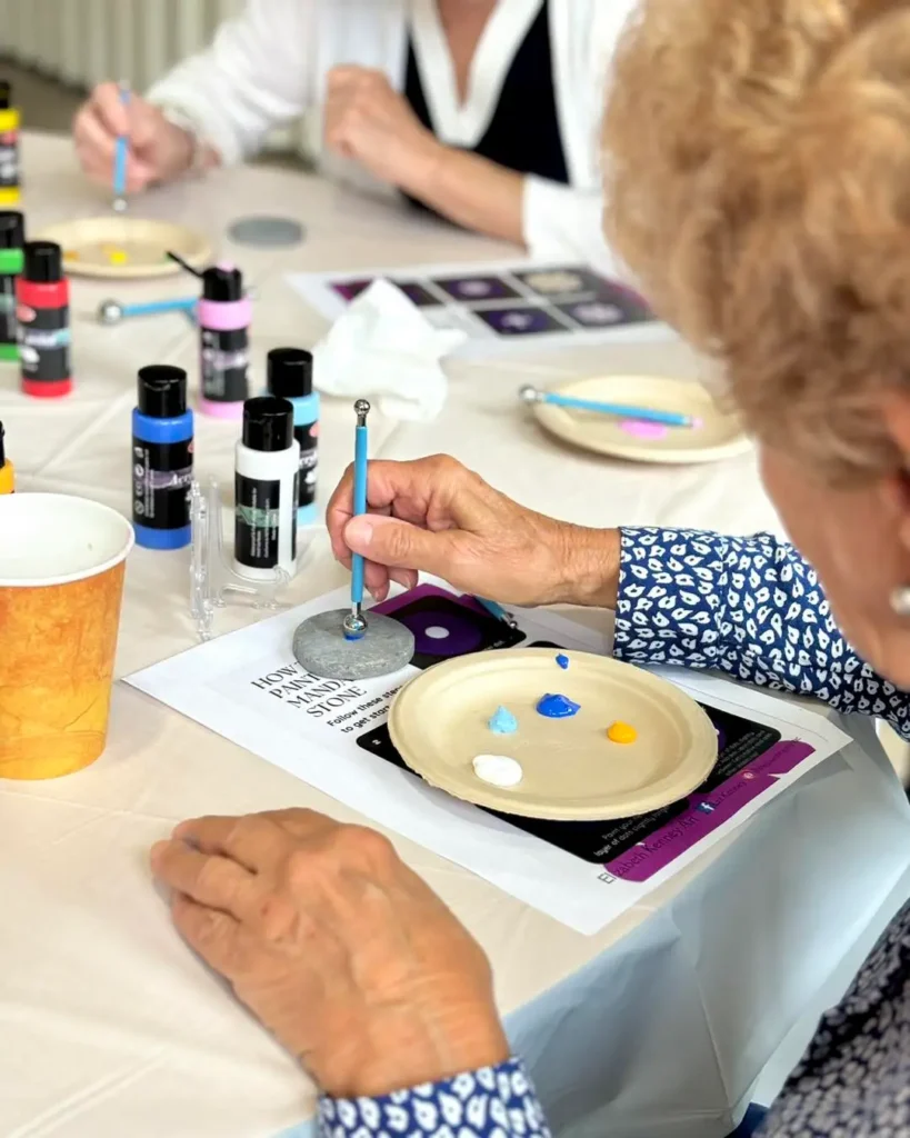 senior woman painting, participating in activities for seniors in assisted living